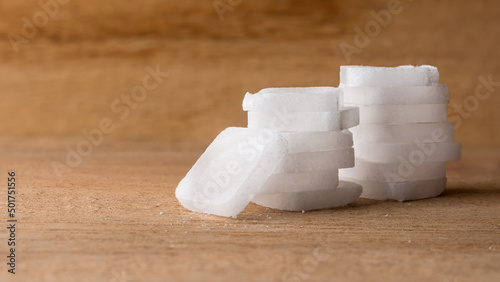 white camphor, cinnamomum camphora tablets on wooden surface, closeup macro with copy space