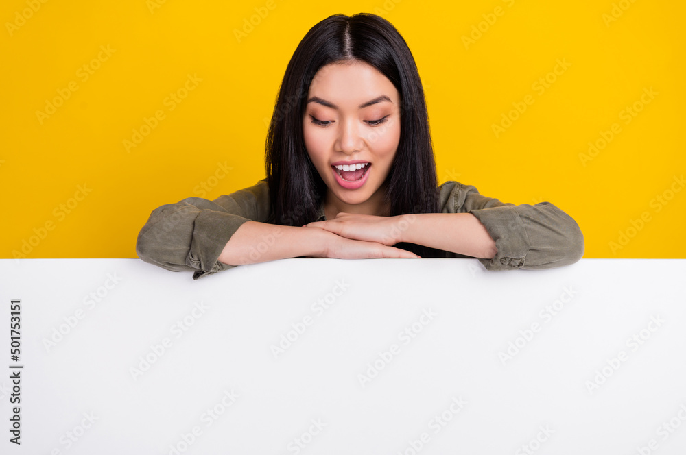 Photo of impressed millennial brunette lady look promo wear khaki shirt isolated on yellow color background Photo of impressed millennial brunette lady look promo wear khaki shirt isolated on yellow color background