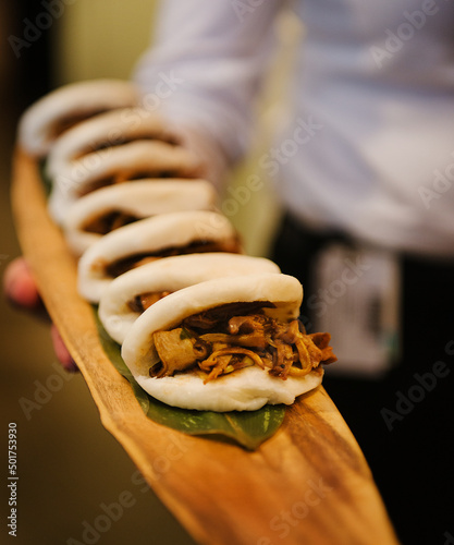 Waiter holding a tray of pork buns. photo