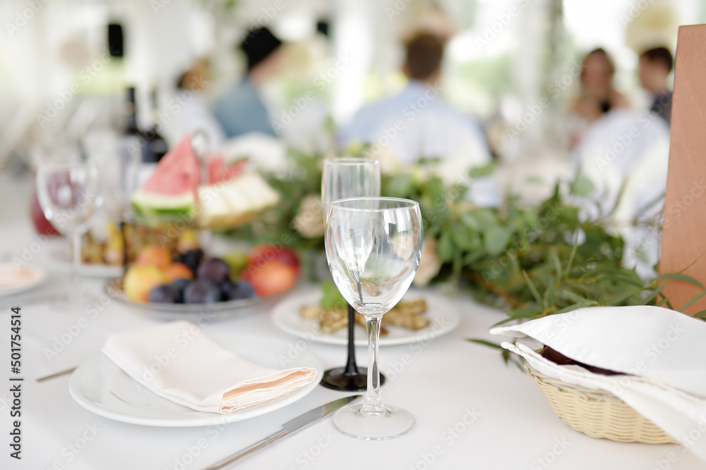 Beautiful table set for a party, wedding reception or festive event. Fruits and appetizers for event dinner. Stylish flowers bouquet.