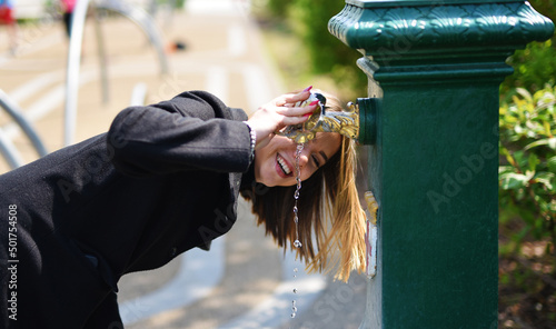 Billede på lærred ragazza felice che beve da una fontanella al parco