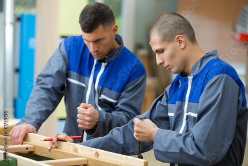joinery workers in workshop with wood