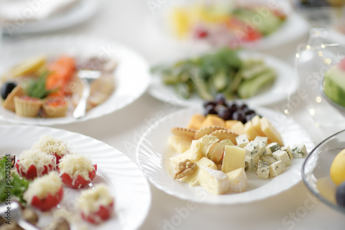Beautiful table set for a party, wedding reception or festive event. Snacks and appetizers for event dinner. Stylish flowers bouquet.