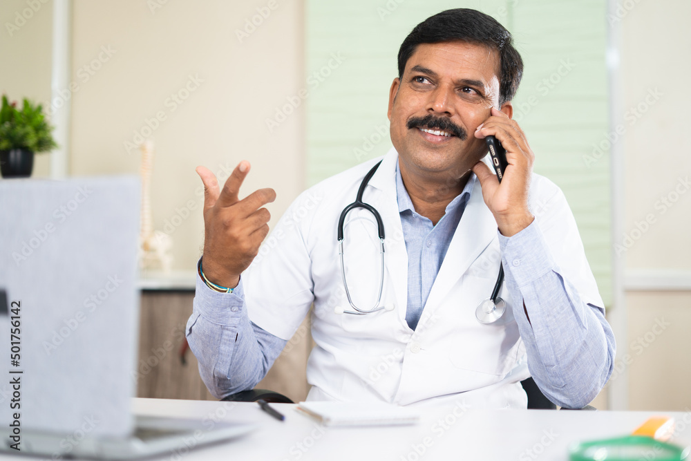 happy smiling doctor busy talking with patient on mobile phone call - concept of communication, support and consultation