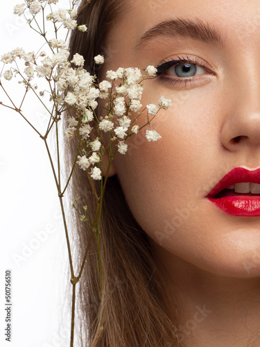 Beautiful brunet model woman face with green eyes and perfect make-up make smile on camera. Portrait of beauty with red lips and eyes liner, thick eyesbrow . Female face with clear skin close-up. photo