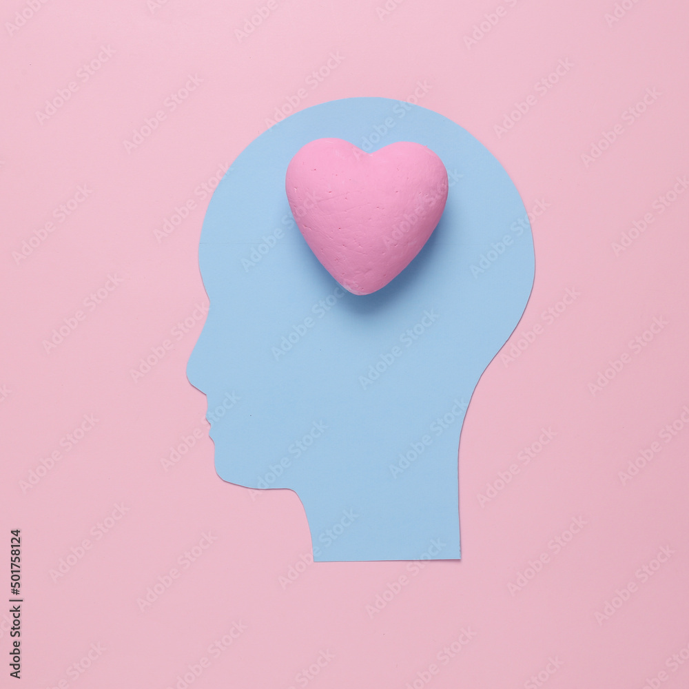 Love concept. Paper cut head with heart instead of brain on pink background Love concept. Paper cut head with heart instead of brain on pink background