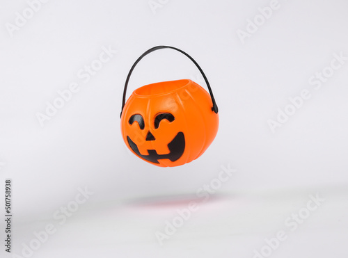 Floating Halloween jack pumpkin bucket on white background with shadow. Trick or Treat photo