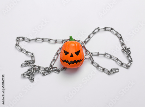 Jack pumpkin head with a Christmas garland on white background. Top view