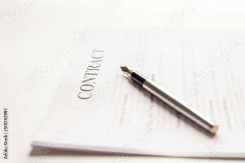 Ink pen lying on a contract or application form, low angle view.