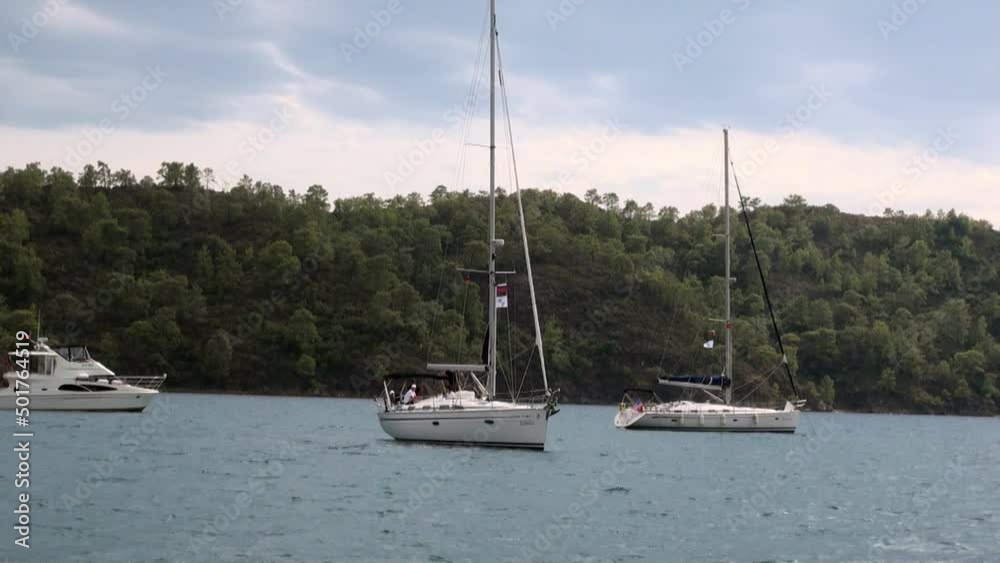 Marmaris, Turkey - September 12, 2010: White yachts on background of blue sea and clouds in sky. Marine life style of travel by sea water. Beautiful seascape and unique coastline landscape. Marmaris, Turkey - September 12, 2010: White yachts on background of blue sea and clouds in sky. Marine life style of travel by sea water. Beautiful seascape and unique coastline landscape.
