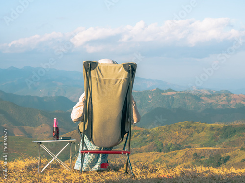 A woman sitting on camping chair at the mountain view point