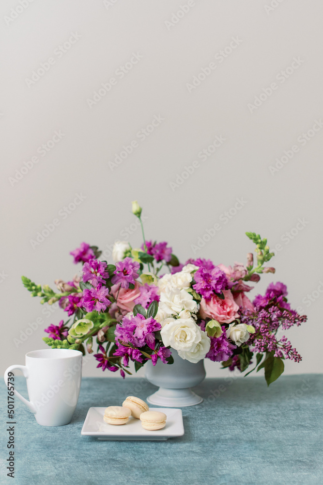 purple flowers and vanilla macarons with cup of coffee