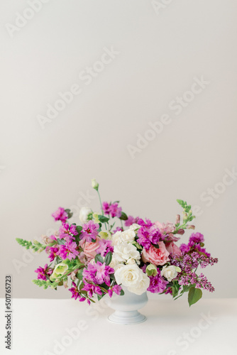 pink and purple spring flower centerpiece in white vase