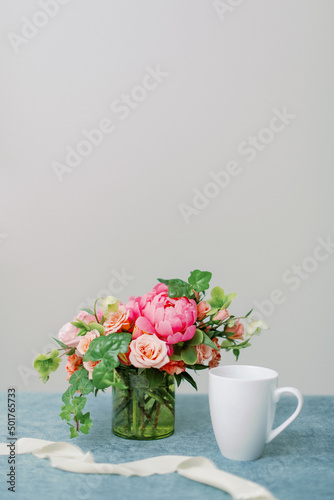 pink and peach flower centerpiece with white coffee mug