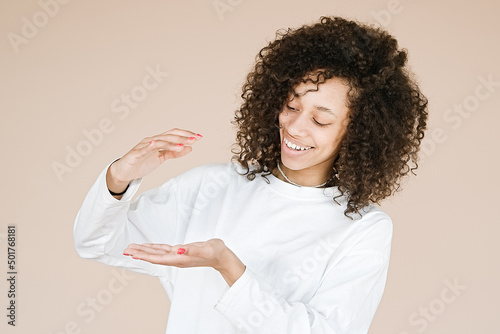 Young African american girl wearing over brown background gesturing with hands showing big and large size sign, measure symbol. Smiling looking at the camera. Measuring      