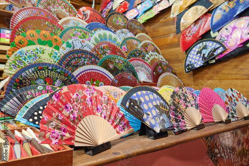 Spanish hand fans made by local artisan, painted by hand are on sale in a bazaar like souvenirs. Hand made items.