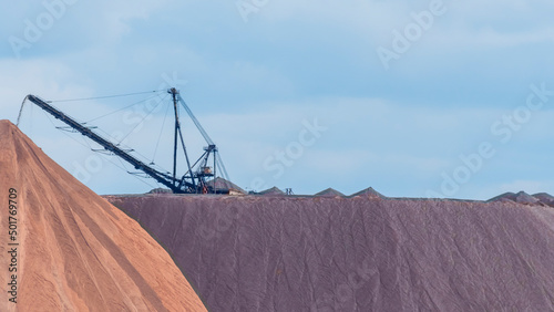 Giant spreader or absetzer machinery. A large dumper on a landfill with potash ore. Extracting potassium salts. photo