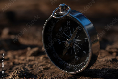 Close up shot of a silver metal compass always pointing it's needle towards North