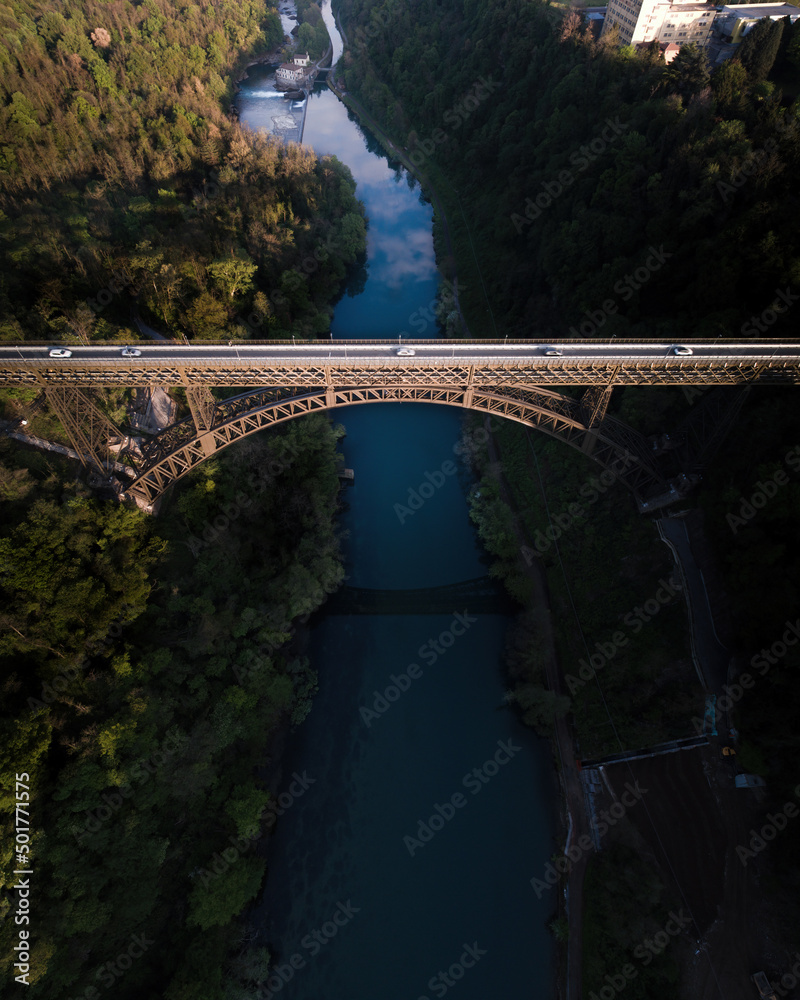 Fototapeta premium Iron bridge over Adda river elightened by the sun.