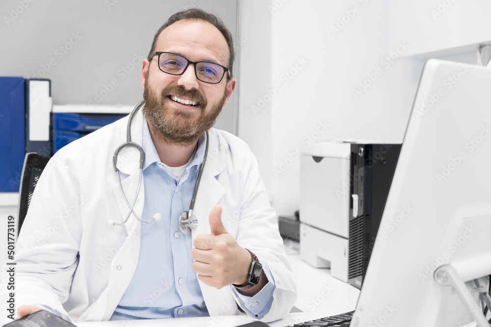 Friendly male doctor smiling and giving thumb up sign. High quality photo Friendly male doctor smiling and giving thumb up sign. High quality photo