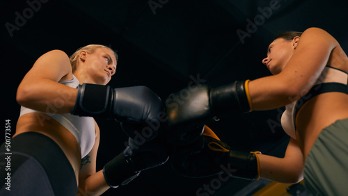 Foto From below horizontal shot of two young women starting sparring match greeting e