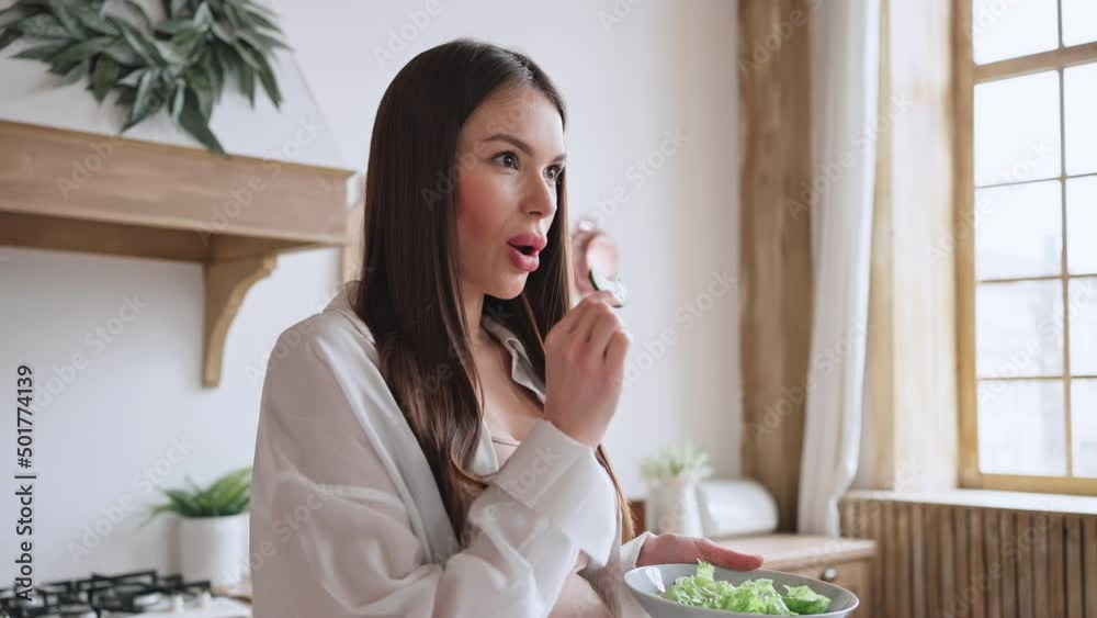 Satisfied pregnant woman tastes cooked salad with vegetables