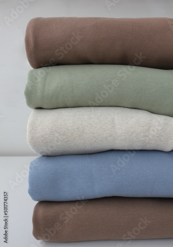 Neatly folded pastel hoodies. fabric texture close-up