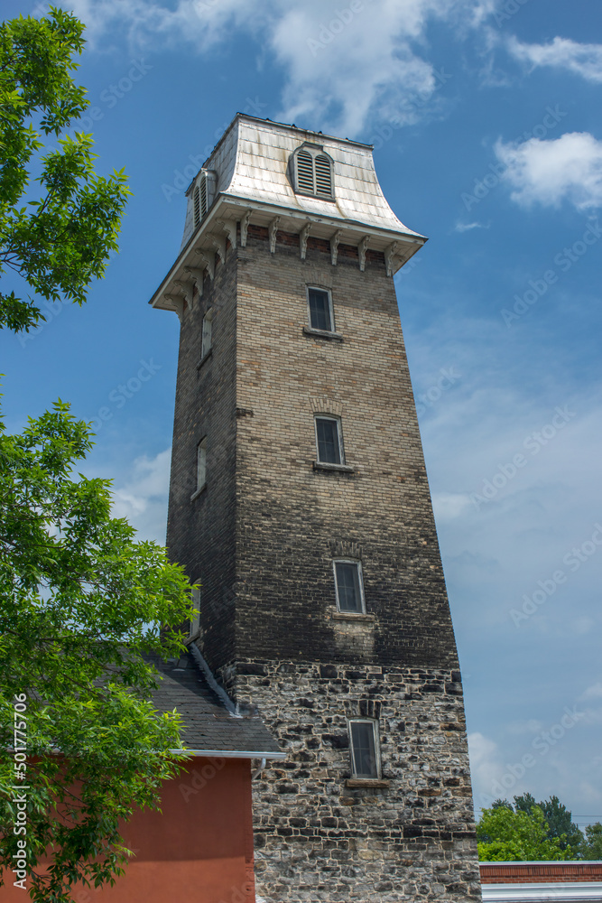 Circa 1855 stone block fire hall tower with Mansard roof, sunny day, nobody