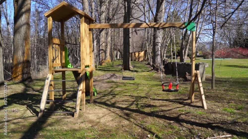 Parque de juegos infantil con columpios vacíos en movimiento