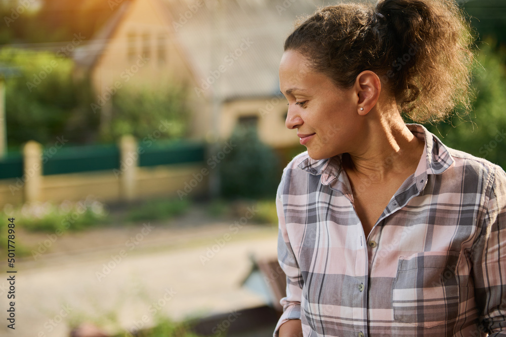 Middle-aged African woman looking away from her country side balcony Middle-aged African woman looking away from her country side balcony