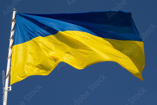 Flag of Ukraine against the background of the blue sky. Close-up.