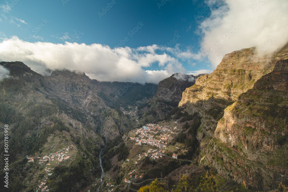 Very well-known tourist destination, Curral das freiras, a village nestled in the mountains with minimal sunlight. Aerial view of valley of nuns at sunset and peak of mountains in fog