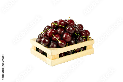 Cherries in box. Sweet fresh cherries in wooden box on white background. Close up image with copy space.
