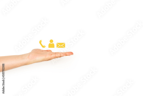 Mano de mujer sosteniedo símbolos de teléfono, correo electrónico y contacto de color amarillo sobre un fondo blanco liso y aislado. Vista de frente. Copy space