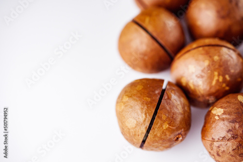 fresh macadamia nuts on a white acrylic background