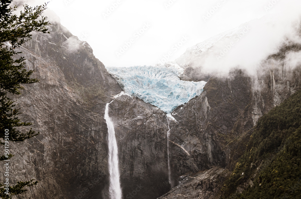 Hanging snowdrift shrouded with clouds in queulat national park