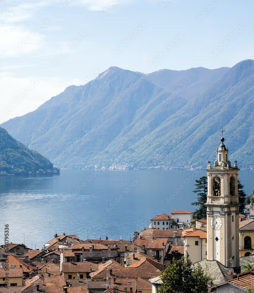 view of the mountains around lake como with a church tower in the foreground