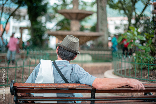 old man sitting on the square of a town in antioquia colombia photo