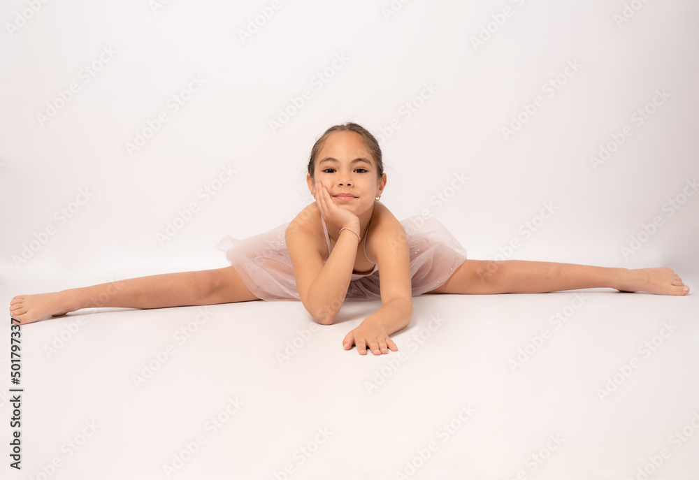 Little ballerina girl laying on the ground and posing for the camera. Little ballerina girl laying on the ground and posing for the camera.