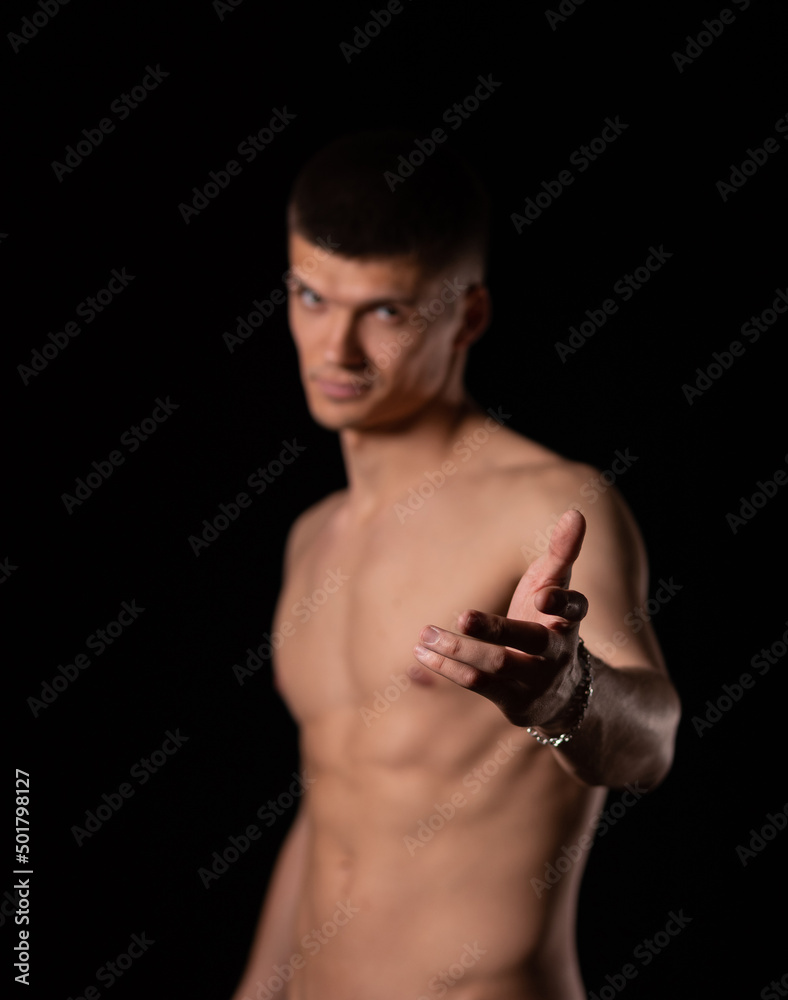 Fototapeta premium Focus on details. strong sexy man holds out his hand on a black background