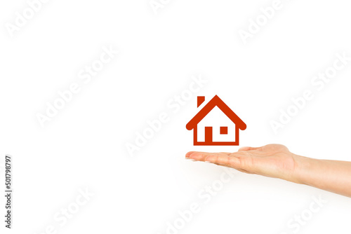 Mano de mujer con la palma abierta sosteniendo un icono de casa sobre un fondo blanco liso y aislado. Vista de frente. Copy space  photo