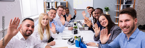 Happy Group Of Businesspeople Waving Hands In Office photo