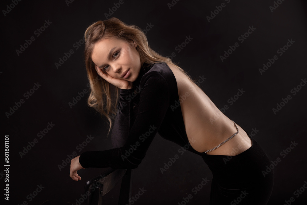 sensual tender beautiful female in black dress with open back
