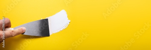 Painter Puttied Yellow Wall With Paint Trowel photo