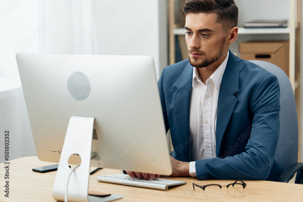 a man in a suit wearing glasses works at a computer office workplace a man in a suit wearing glasses works at a computer office workplace
