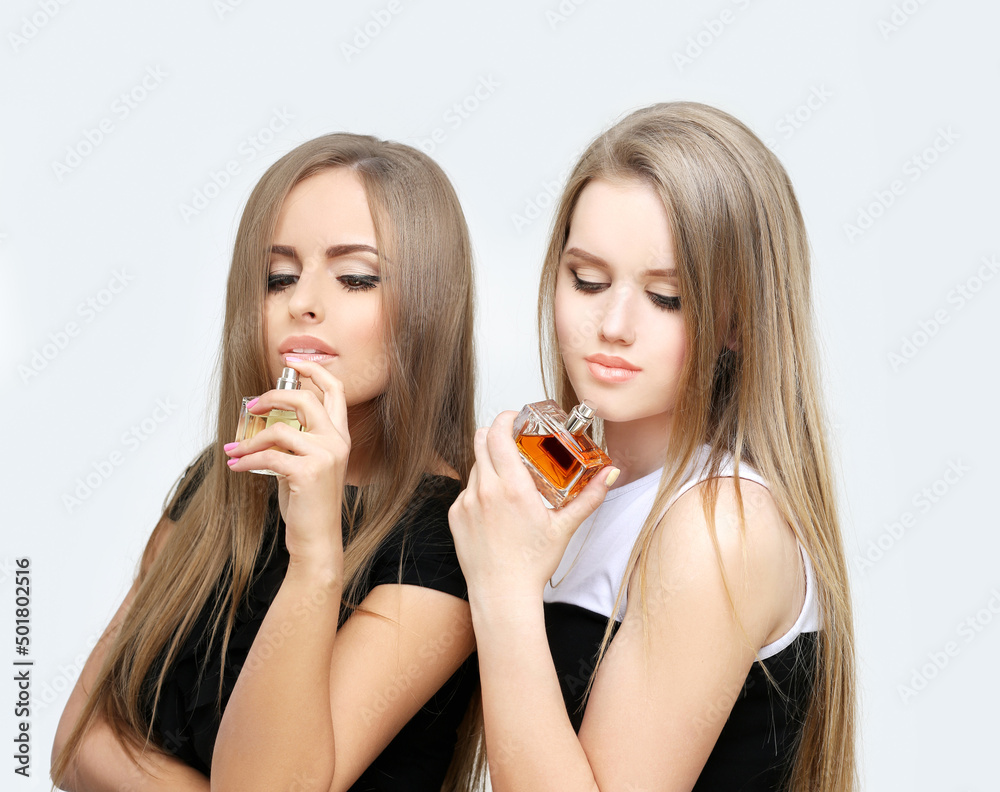 Perfume. Young girls smelling aroma with pleasure Perfume. Young girls smelling aroma with pleasure