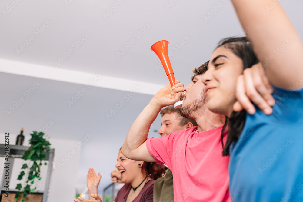 friends cheering for their team after scoring a point in their favour. sport broadcast on television. friends cheering for their team after scoring a point in their favour. sport broadcast on television.
