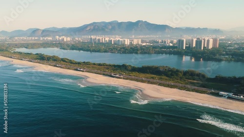Aerial view of Reserva beach, Marapendi lagoon and car traffic on Lucio Costa avenue. Barra da Tijuca and Recreio, in Rio de Janeiro, Brazil. Sunrise. Sunny day. Drone take. Praia da Reserva.