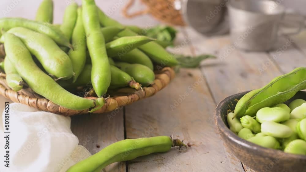 Fresh and raw green broad beans on wooden table. Fresh and raw green broad beans on wooden table.