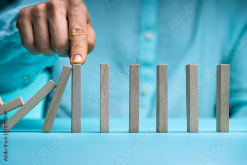 Konstfotografi Close-up Of Businessman Stopping The Effect Of Domino With Hand